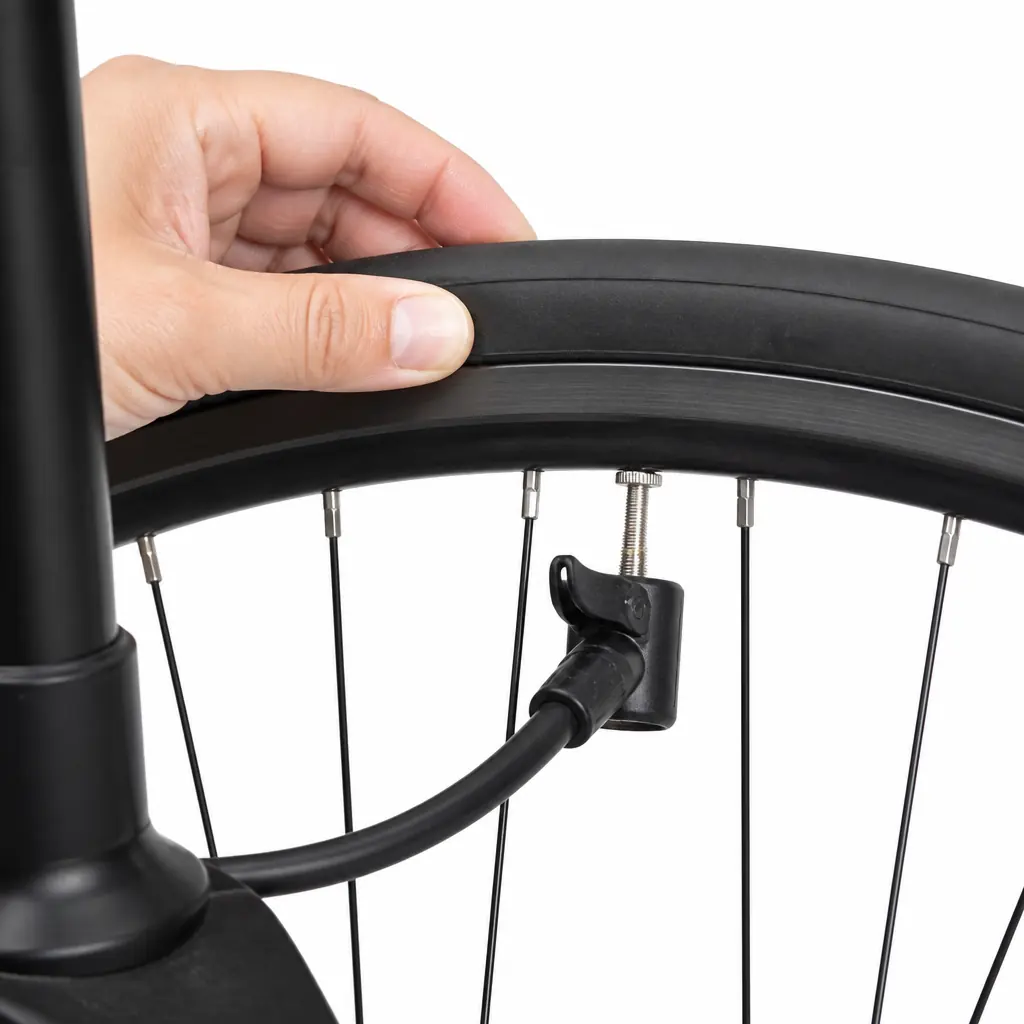 自転車タイヤ交換後に、フロアポンプで少し空気を入れながらタイヤ側面のビードラインを確認している写真
